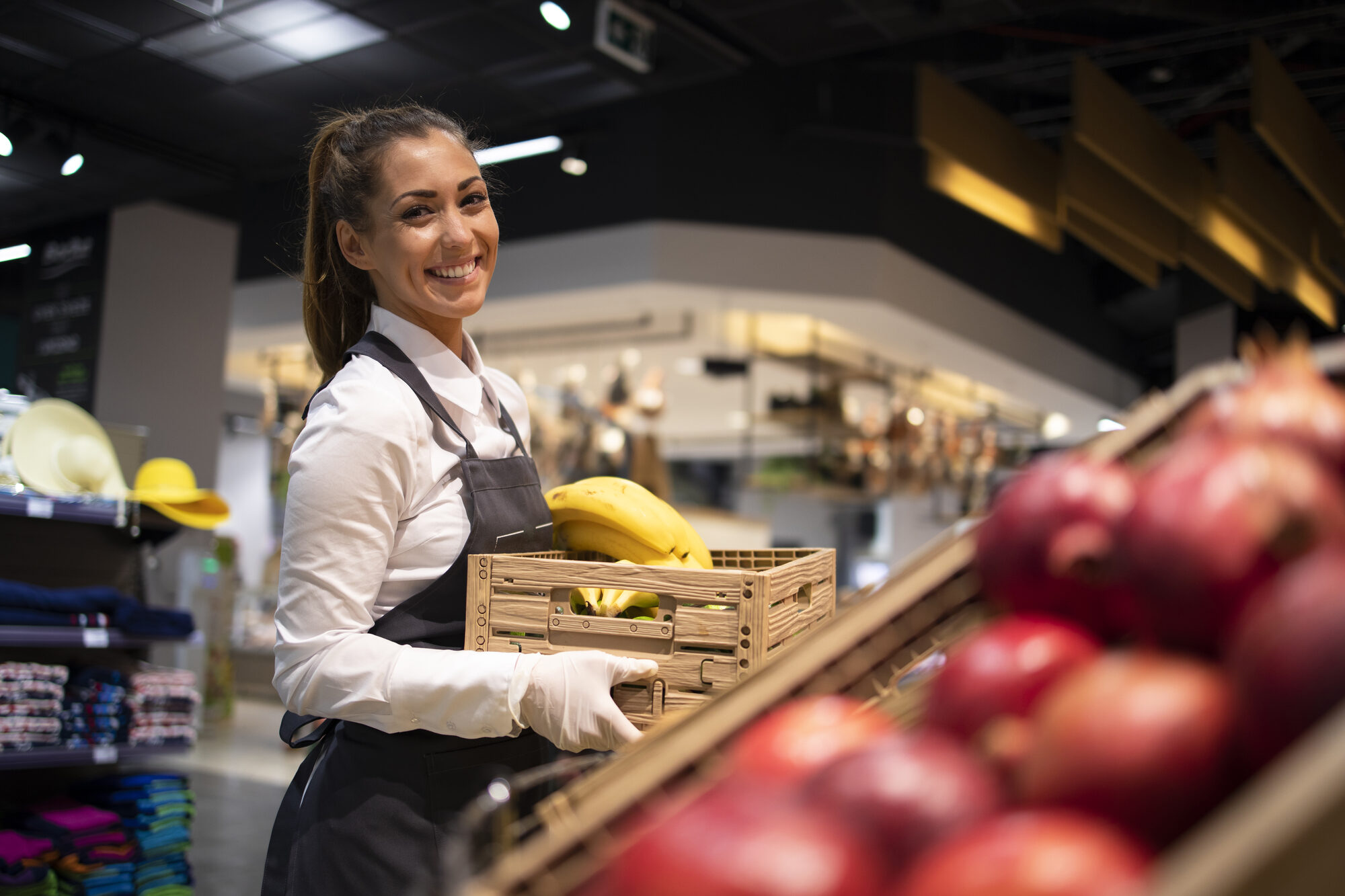 Supermarket worker supplying the fruit department with fresh produce