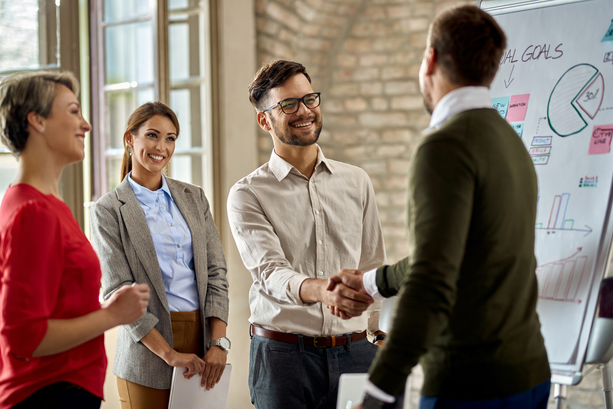 Colleagues shaking hands after a business presentation
